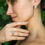 Model wearing blue topaz pendant styled with hand on chest showing fine chain and stone clarity