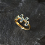 Special occasion ring with vivid blue topaz stones and sleek gold band.