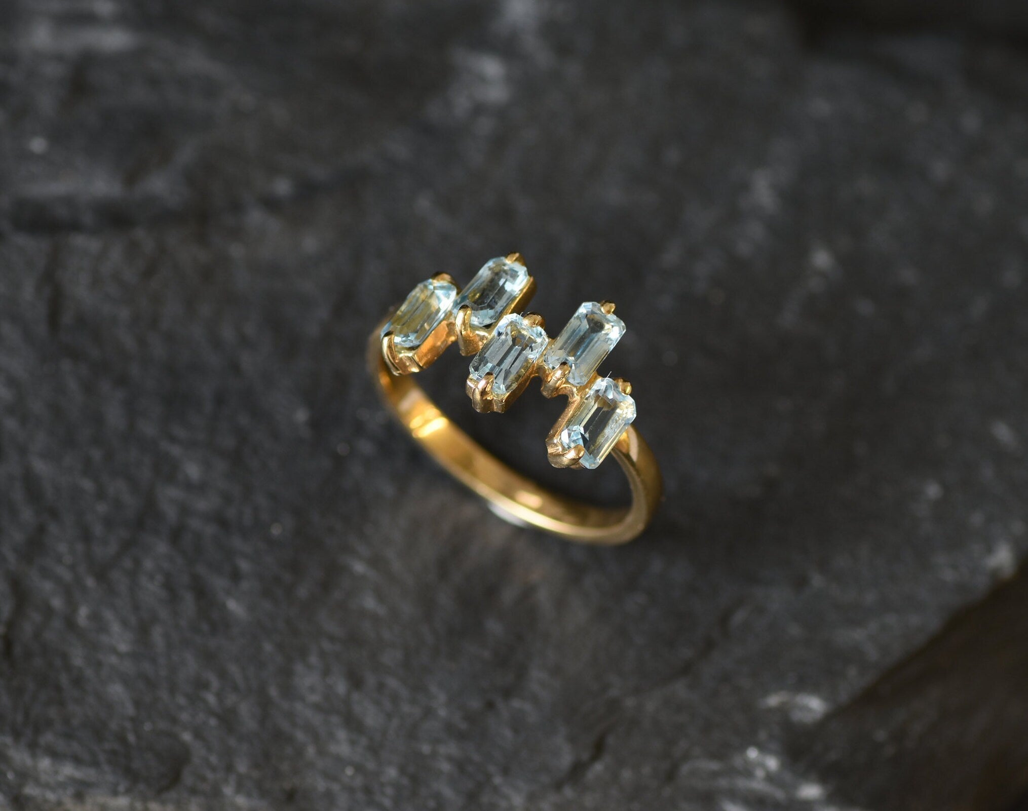 Special occasion ring with vivid blue topaz stones and sleek gold band.