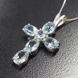 Blue Topaz cross necklace highlighting December birthstone magic