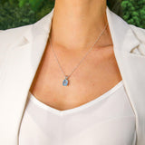 Blue topaz silver pendant worn with open neckline showcasing its clarity and elegant chain length