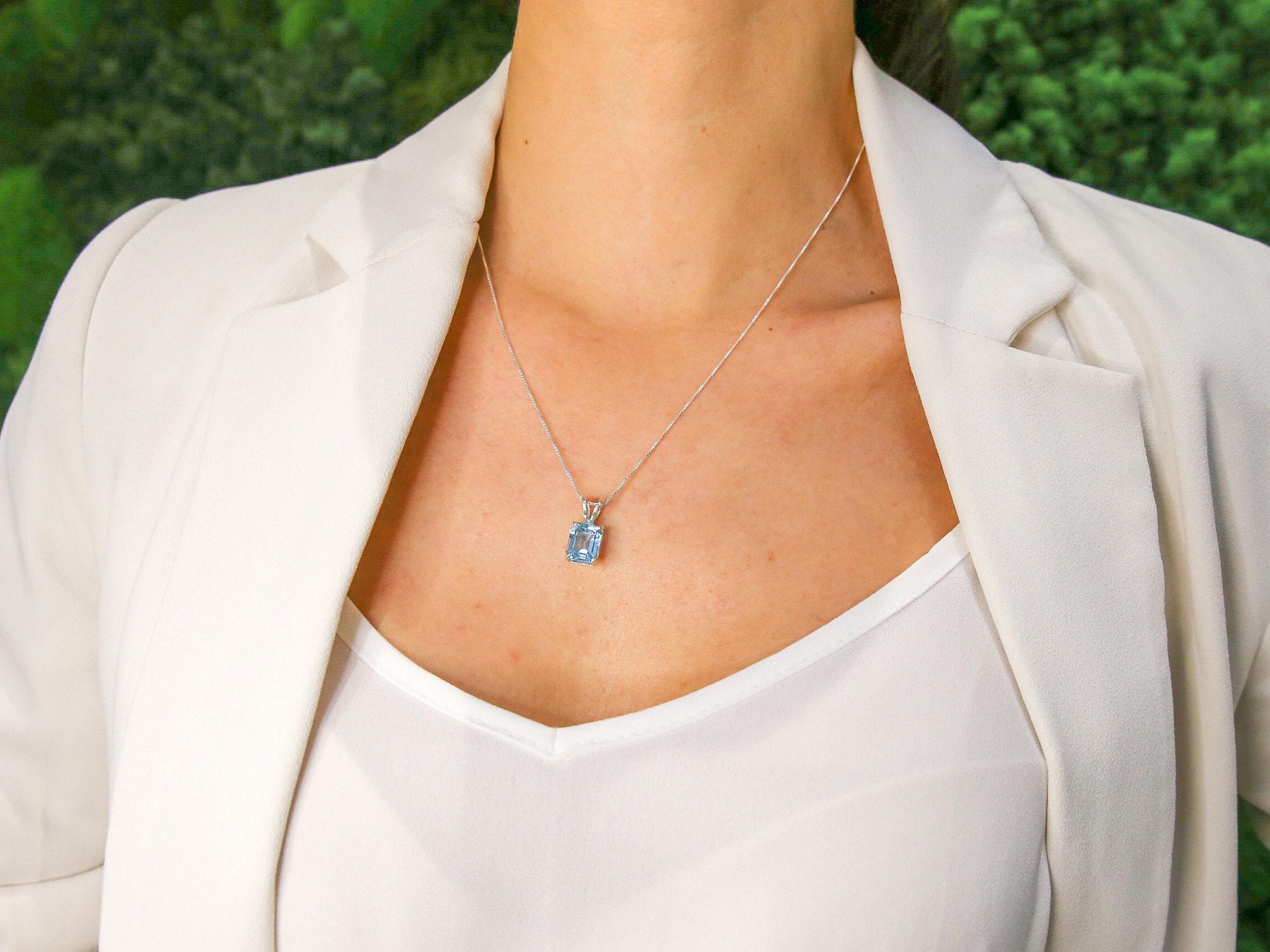 Blue topaz silver pendant worn with open neckline showcasing its clarity and elegant chain length