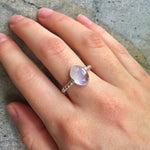 Natural Rainbow Moonstone ring worn on the middle finger, lit with natural light and styled for effortless boho elegance, ideal with breezy neutrals.