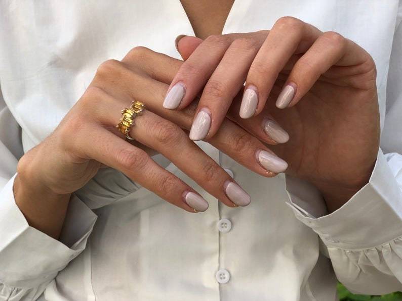 Woman modeling five-stone citrine gold ring on hand highlighting brilliance and yellow gemstone clarity