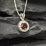 Dainty round garnet necklace, in a round cut and prong setting, with small CZ diamonds.