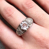 Diamond ring on middle finger styled with soft nude nails, complementing casual to formal wear effortlessly.