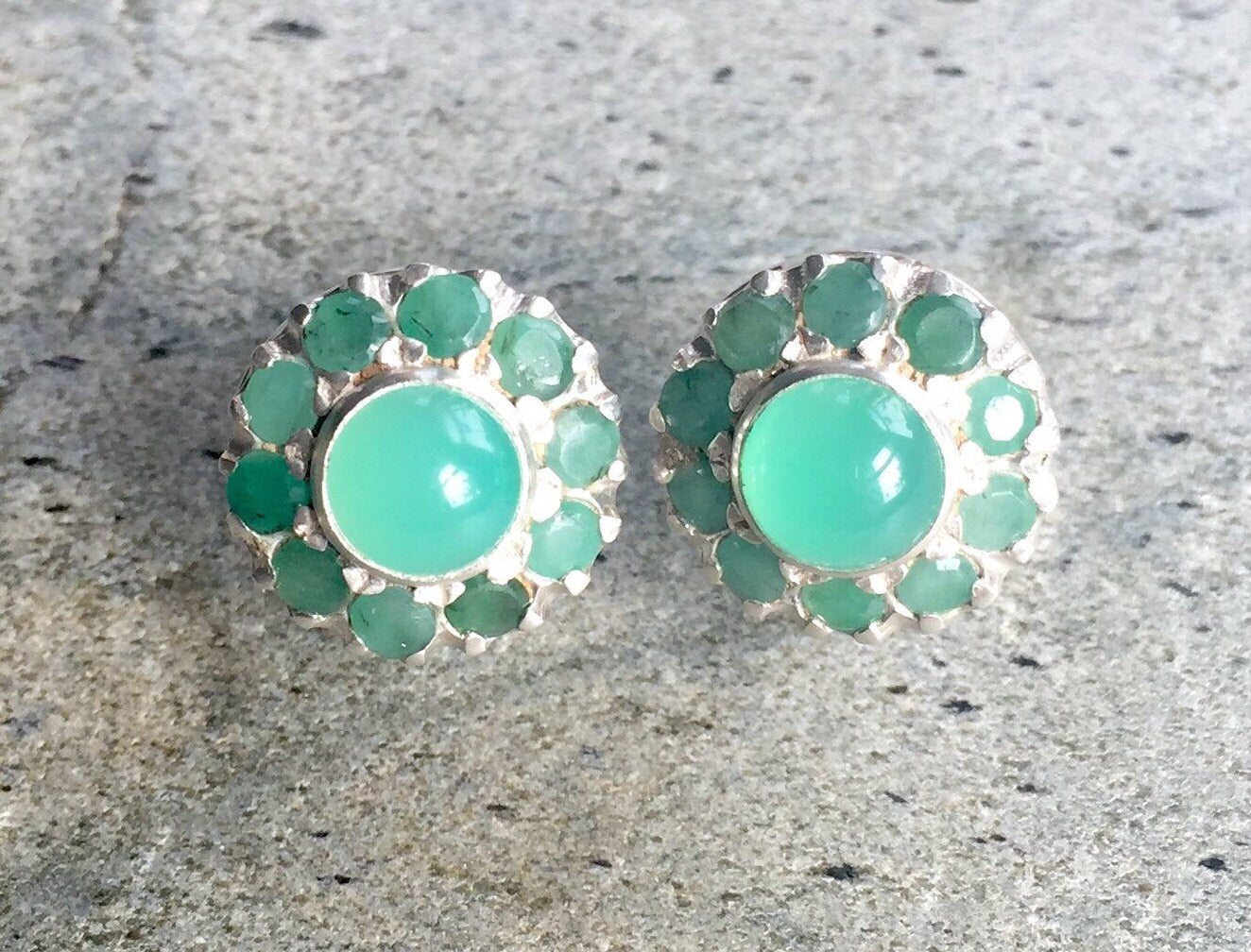 A serene landscape featuring rolling hills, a bright blue sky, and fluffy white clouds beneath a warm sunlight glow.