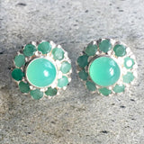 A serene landscape featuring rolling hills, a bright blue sky, and fluffy white clouds beneath a warm sunlight glow.