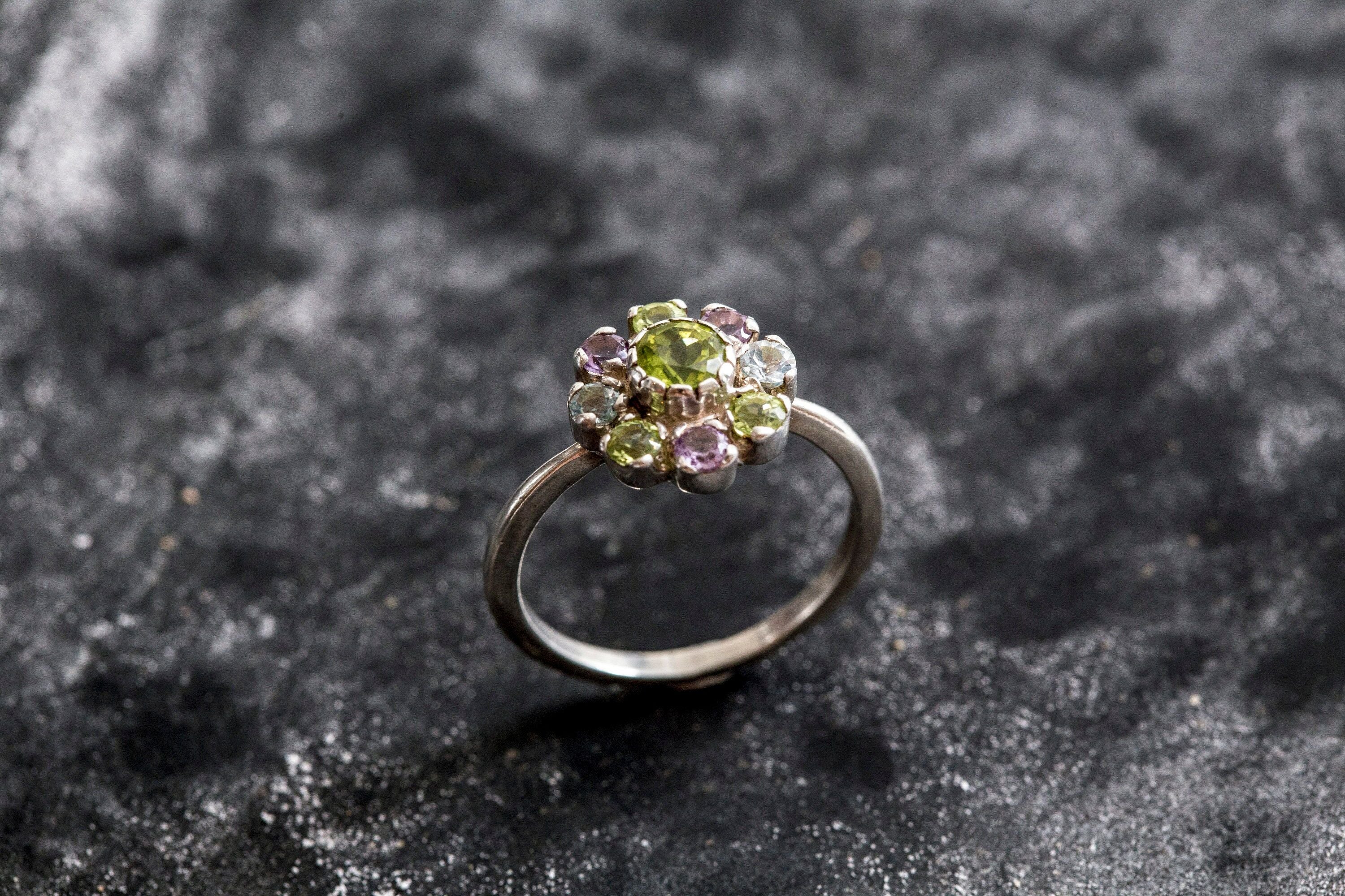 Flower-inspired Peridot ring with Amethyst and Blue Topaz gemstones in sterling silver, timeless jewelry design.