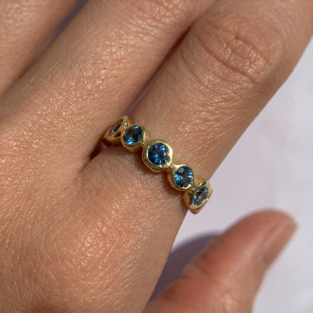 Close-up of created aquamarine ring in 18k gold vermeil, round blue stone in bezel setting