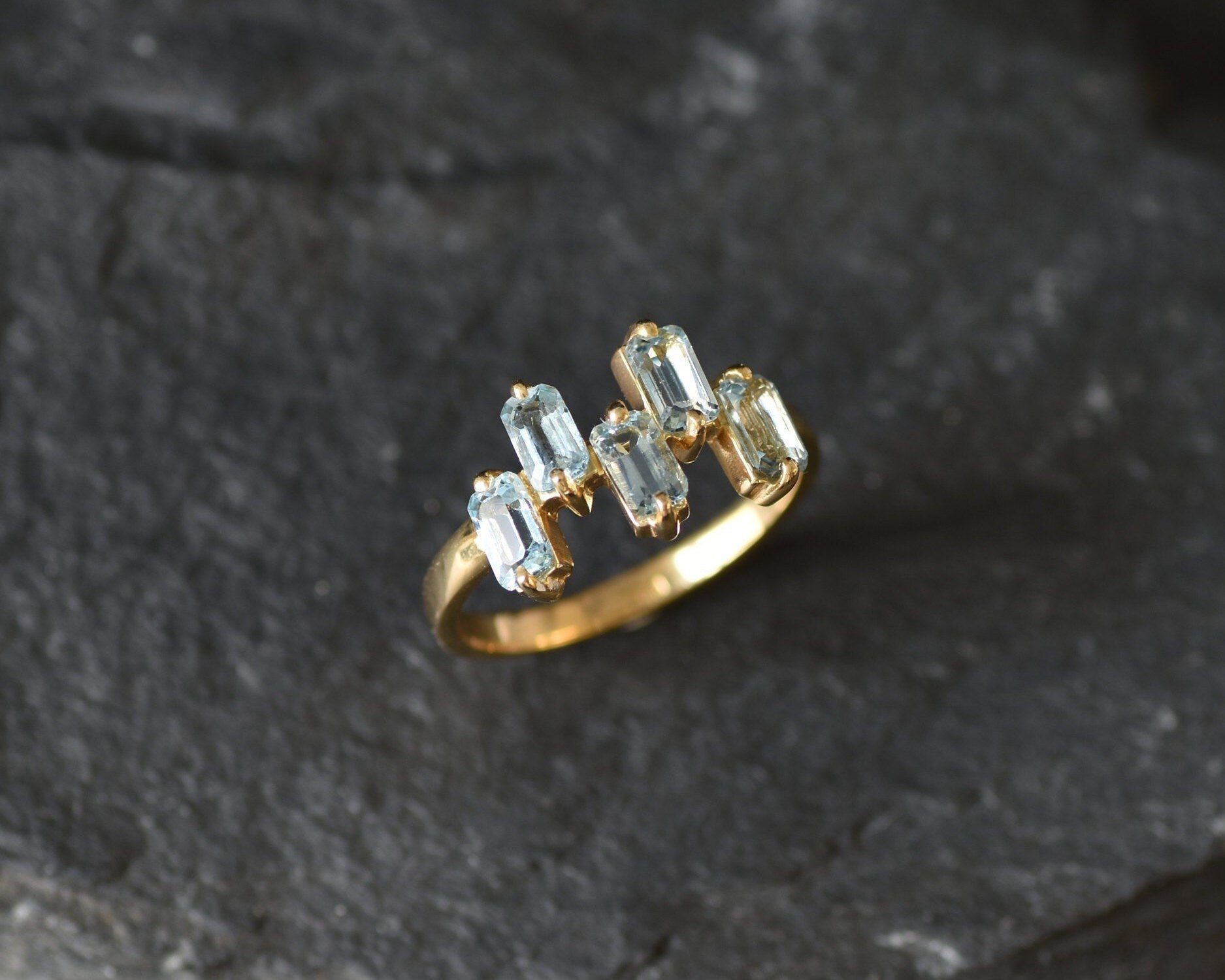 Gold band ring with topaz gems ideal for fashionable gifting or birthstone charm.