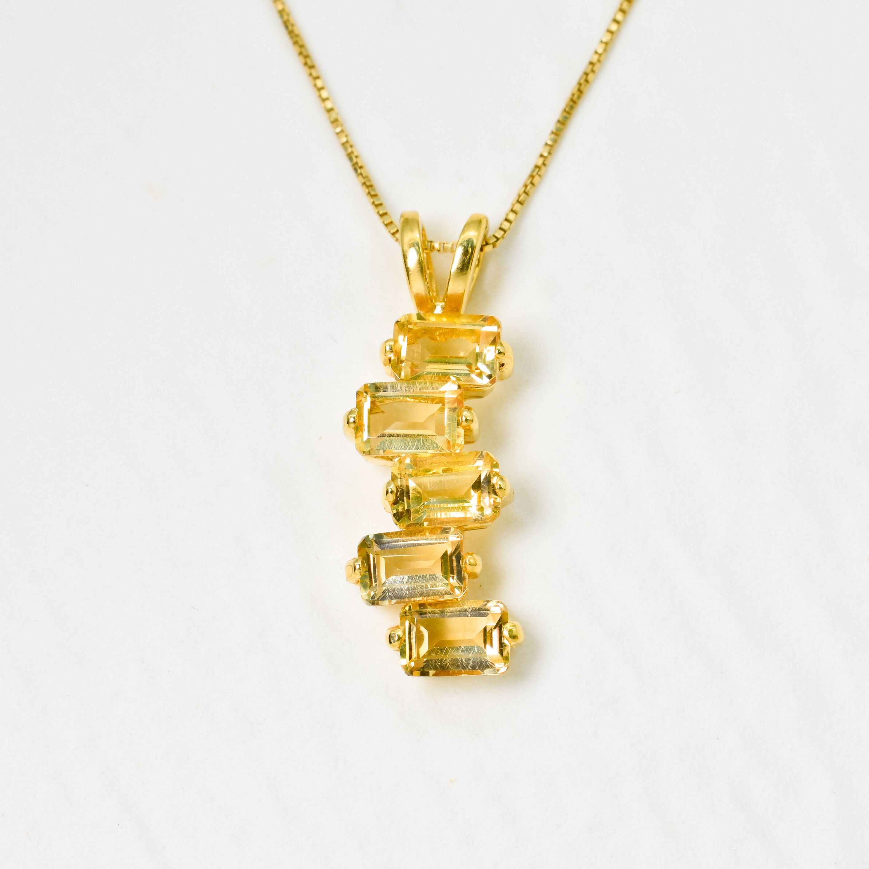 Gold pendant featuring multiple 6x4mm diamond cut natural citrine stones stacked vertically