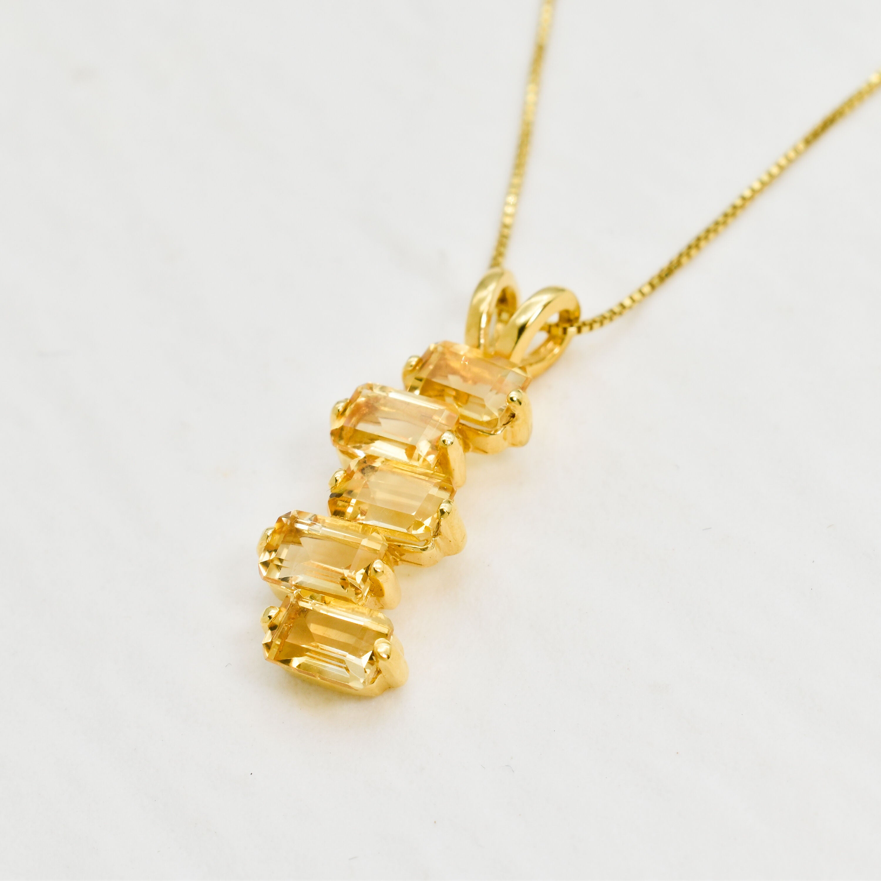 Side view of gold citrine pendant showing the depth and sparkle of diamond cut stones