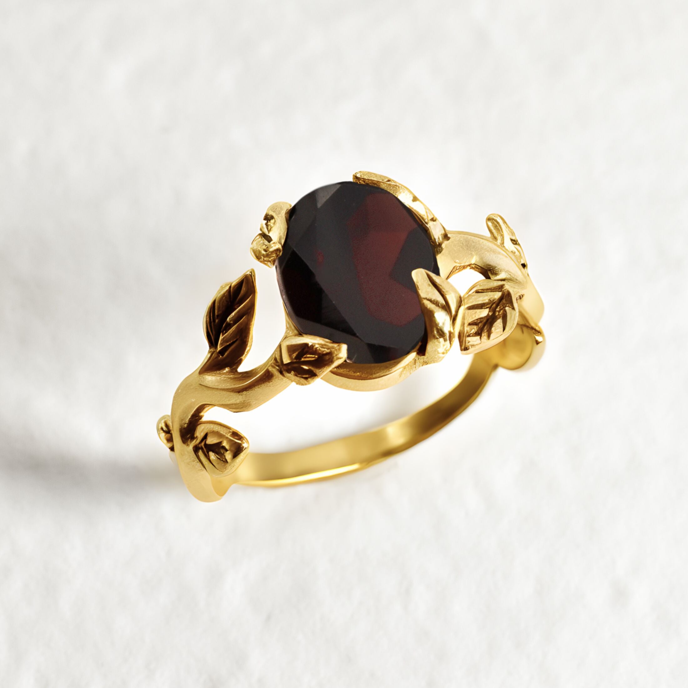 Natural Garnet January birthstone ring set in 18k yellow gold vermeil over solid 925 sterling silver, in prong setting, and leaf-inspired band. Red solitaire gemstone ring promotes energy, passion, and safety in travel. Often associated with love and commitment. Perfect for special occasions, and ideal birthday present
