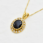 Close-up of gold vermeil pendant featuring natural onyx stone surrounded by sparkling CZ diamonds