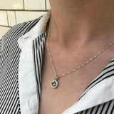 Natural Peridot Pendant resting on skin with buttoned blouse, showcasing timeless gemstone elegance, perfect as a thoughtful birthday gift or gemstone keepsake.