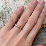 Morganite gold ring worn on hand outdoors highlighting pink stones and band design
