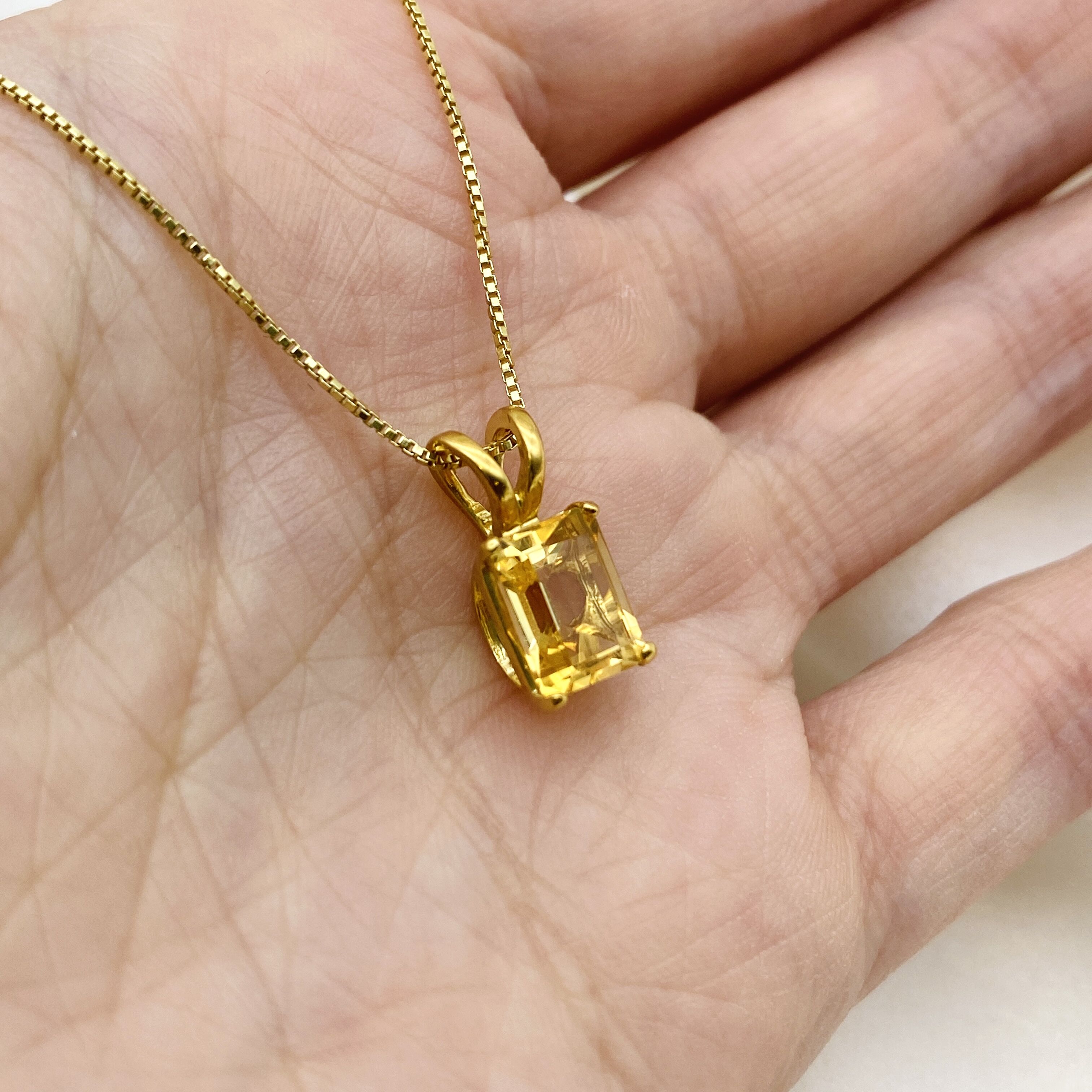 Natural citrine gemstone necklace in 18k gold vermeil resting in open palm - delicate November birthstone jewelry, in emerald cut and prong setting