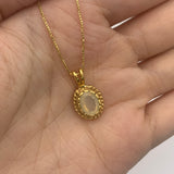 Natural fire opal pendant in 18k yellow gold resting in an open palm – vintage-inspired necklace for size reference