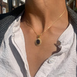 Woman wearing natural onyx pendant necklace with deep black stone and gold vermeil chain