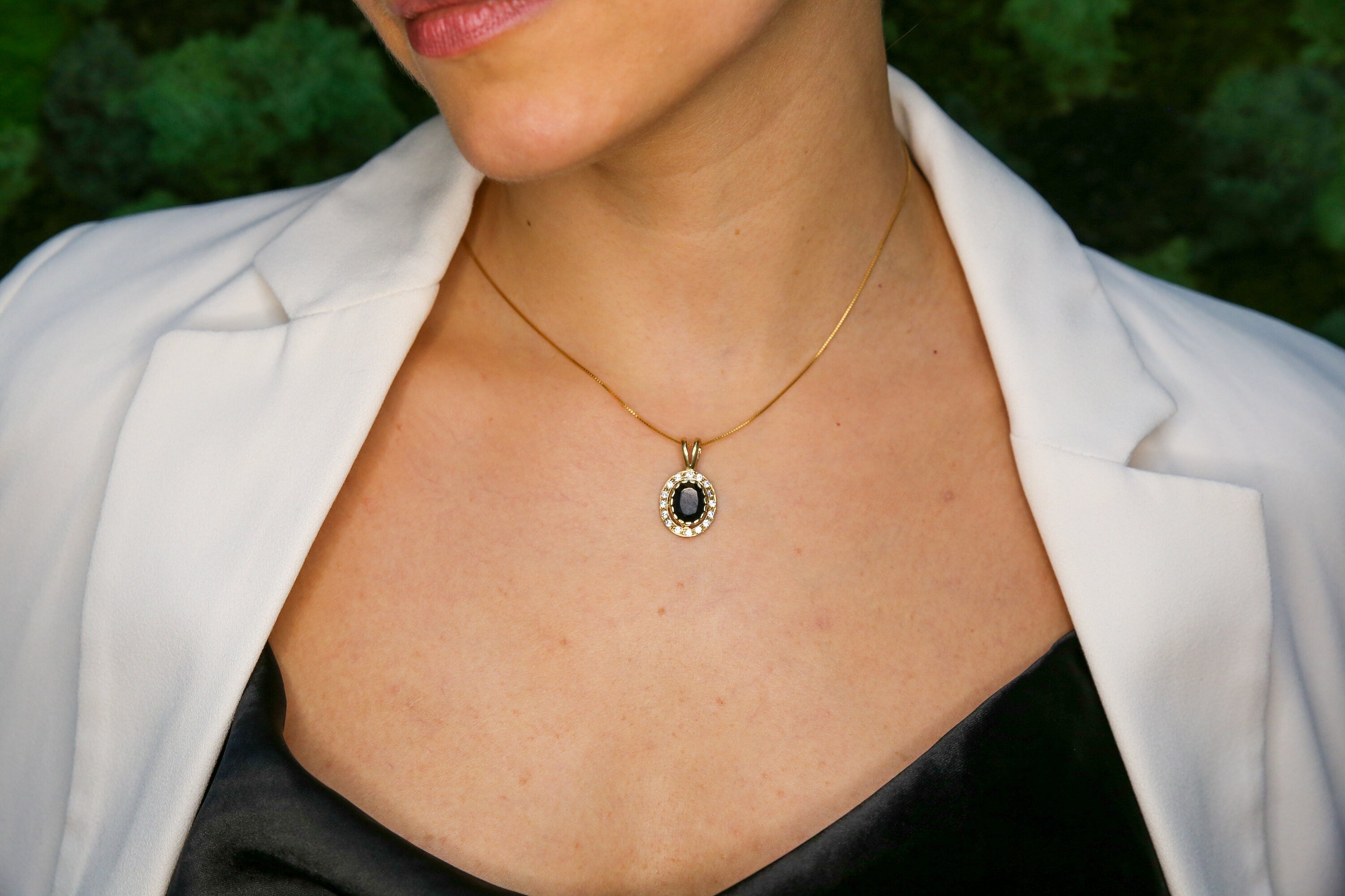 Woman wearing natural onyx pendant necklace paired with white shirt highlighting vintage design