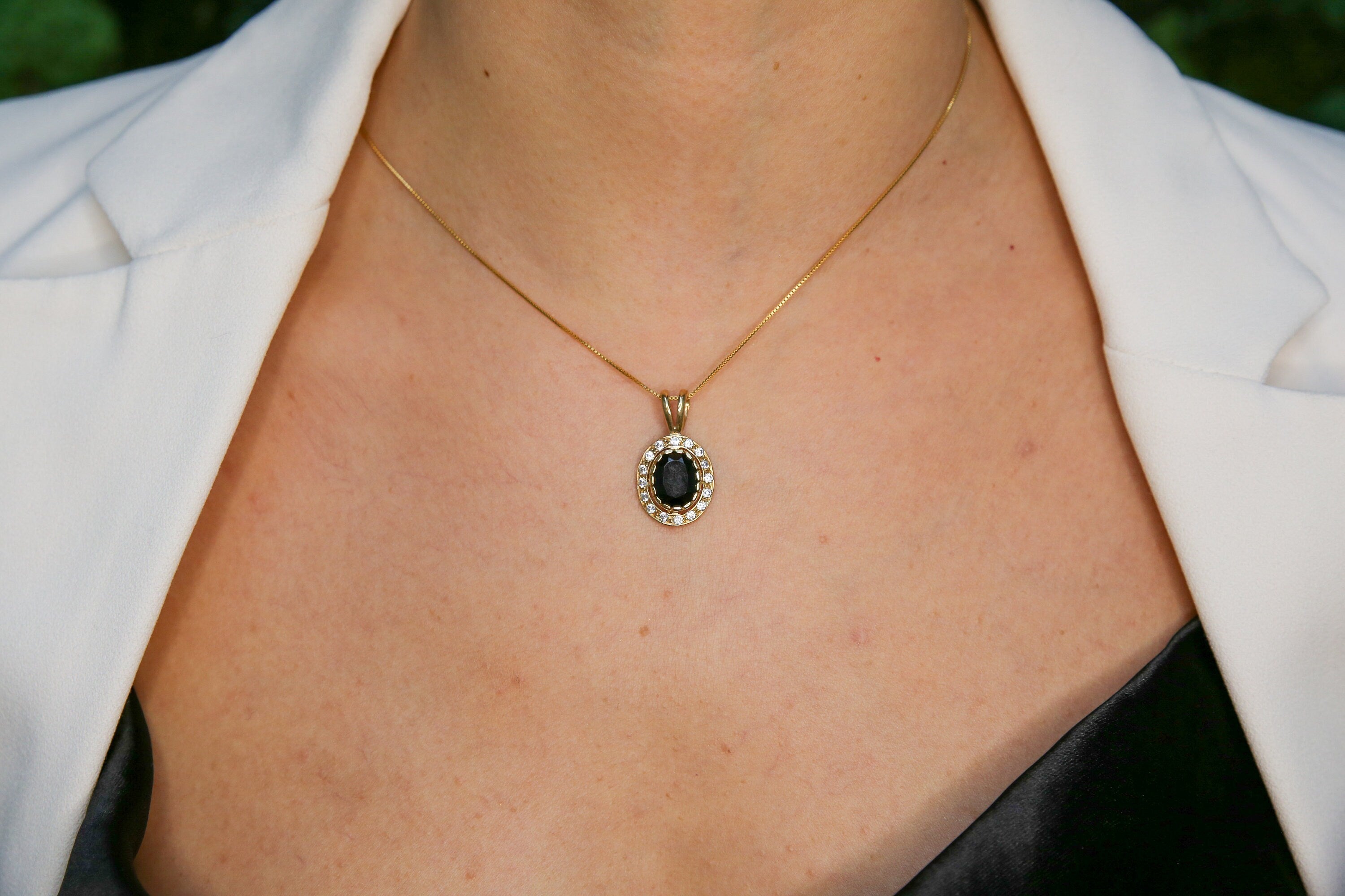Woman wearing natural onyx pendant necklace paired with white shirt highlighting vintage design