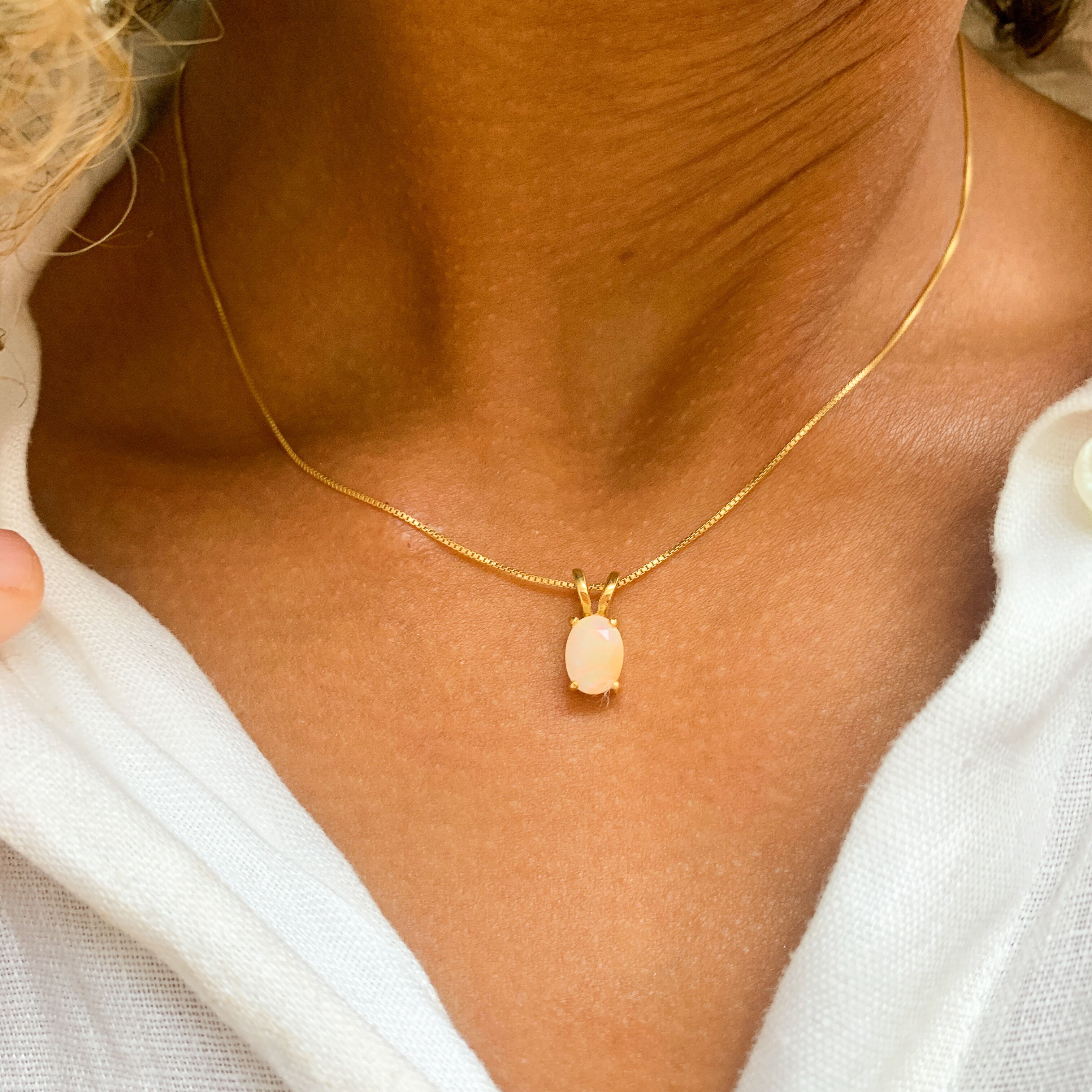 Woman wearing Natural Opal Pendant set in 18k gold vermeil over solid 925 sterling silver, in oval cut, and prong setting. October birthstone necklace perfectly worn for minimalist styles