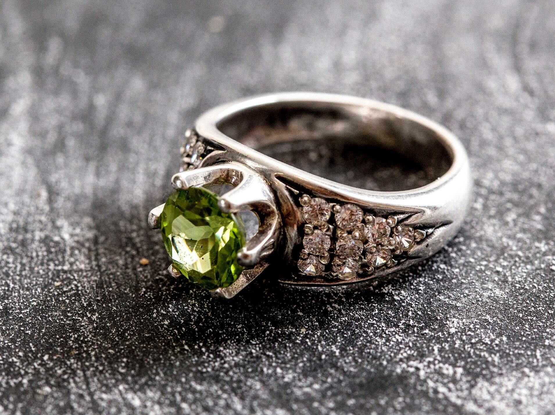 Natural Peridot engagement ring with intricate detailing, known for its vibrant green hue, ideal for special life milestones.