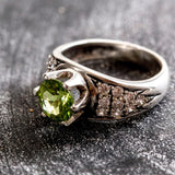 Natural Peridot engagement ring with intricate detailing, known for its vibrant green hue, ideal for special life milestones.