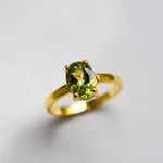 Oval Peridot gemstone ring with refined gold band, ideal for celebrating birthdays, weddings, or anniversaries.