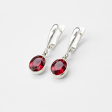 Elegant ruby earrings in sterling silver, featuring oval red stones, perfect for everyday wear and July birthdays.