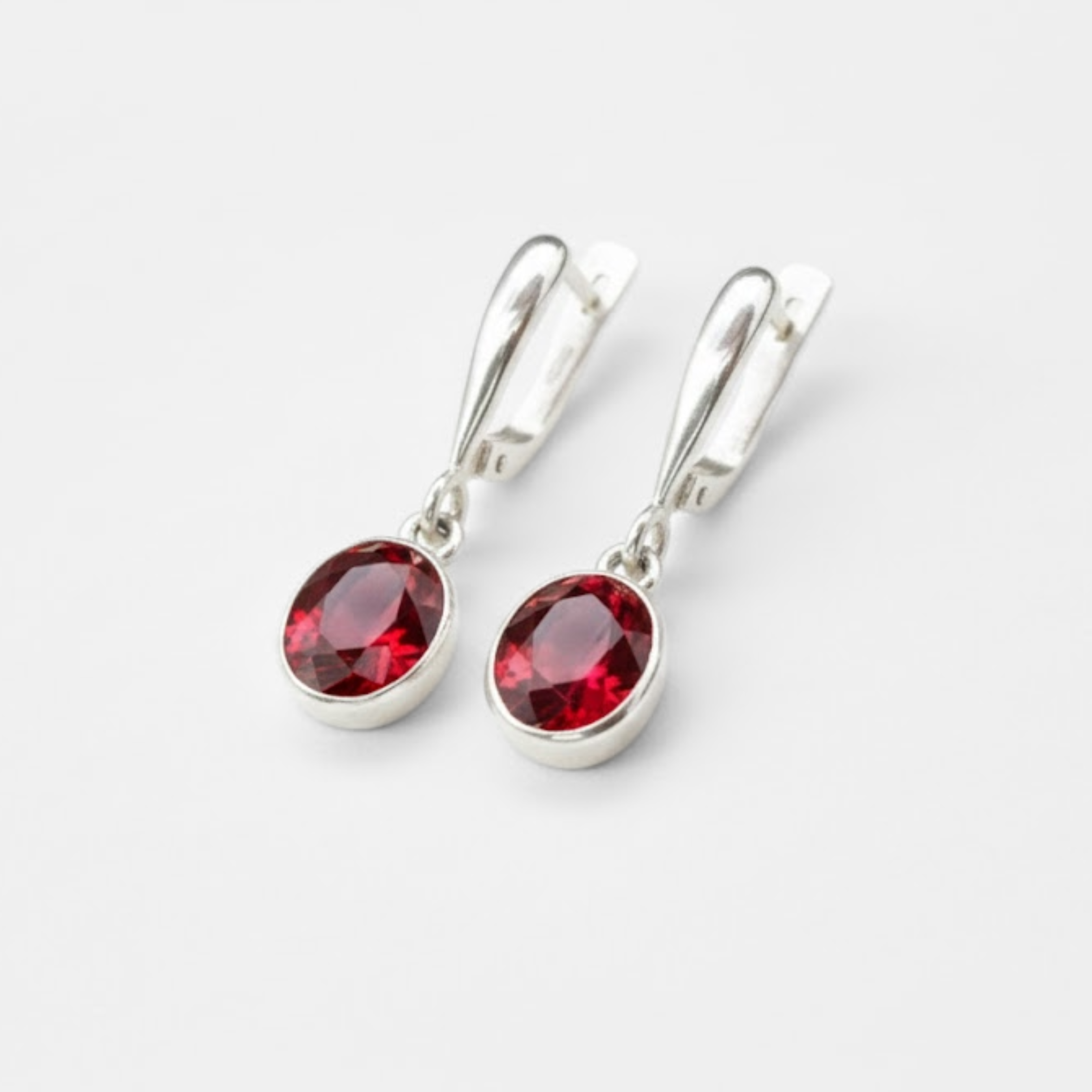 Elegant ruby earrings in sterling silver, featuring oval red stones, perfect for everyday wear and July birthdays.
