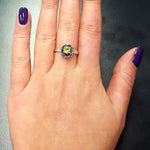 Peridot gemstone ring on middle finger, paired with clean nail look for a casual yet earthy style perfect for everyday wear.