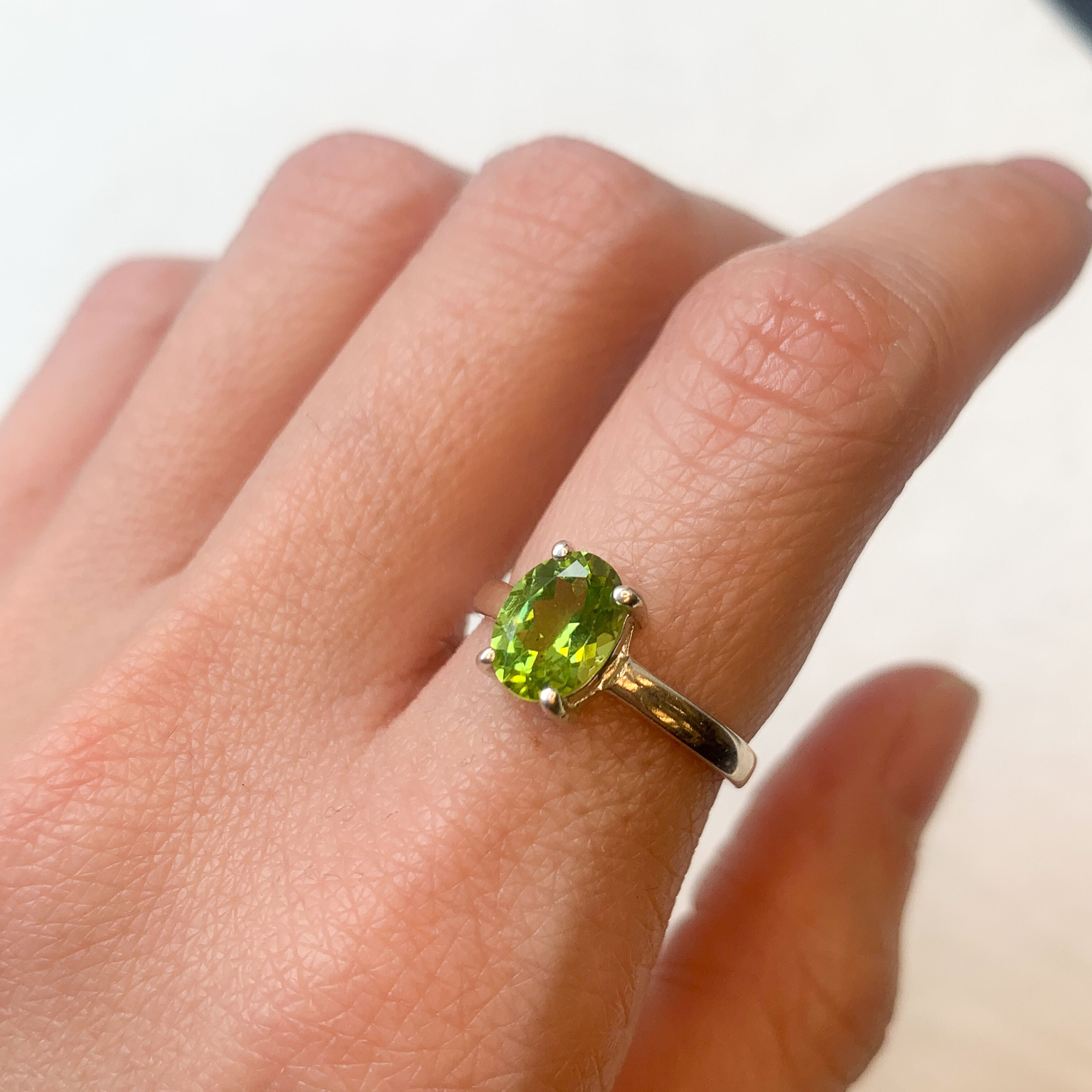 Natural Peridot ring worn on index finger, paired with casual everyday outfit, perfect for adding subtle elegance.