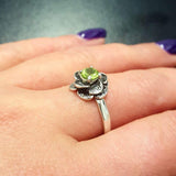 Natural Peridot ring worn on middle finger, styled with bold purple nails, ideal for confident looks and nature-inspired outfits.