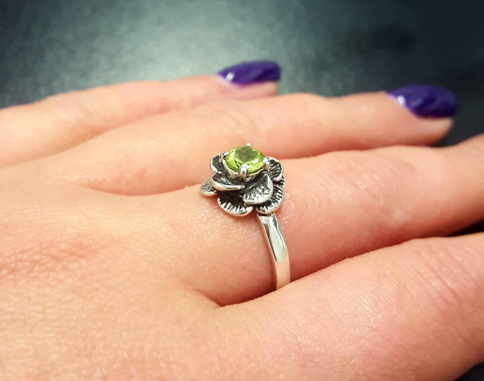 Natural Peridot ring worn on middle finger, styled with bold purple nails, ideal for confident looks and nature-inspired outfits.