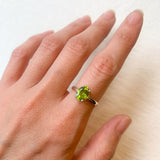 Peridot ring styled on hand with soft-toned manicure, versatile for office wear or sophisticated day looks.