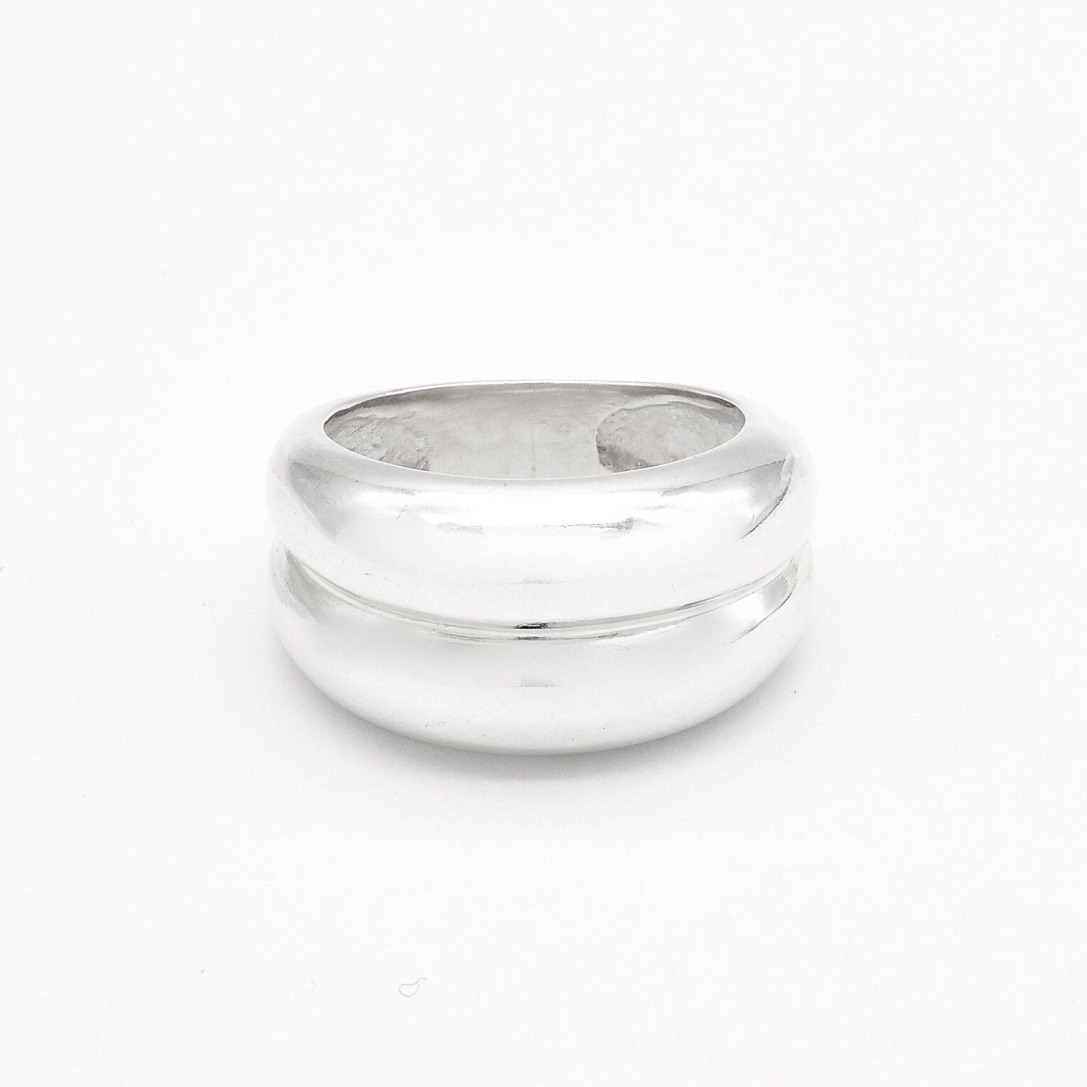 Flat lay image of a polished solid 925 sterling silver band ring on a white background.