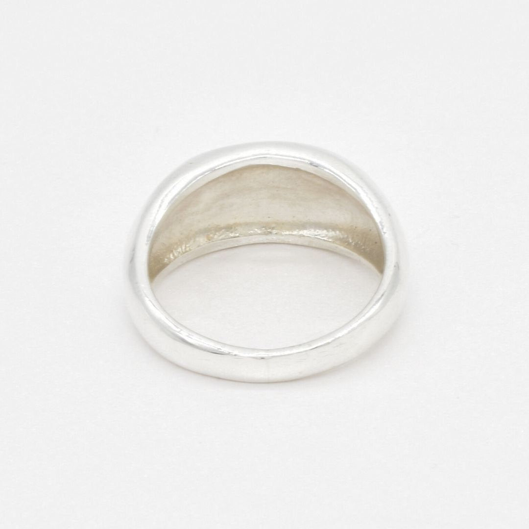 Top view of a polished solid 925 sterling silver band ring, capturing its domed profile and reflective surface.
