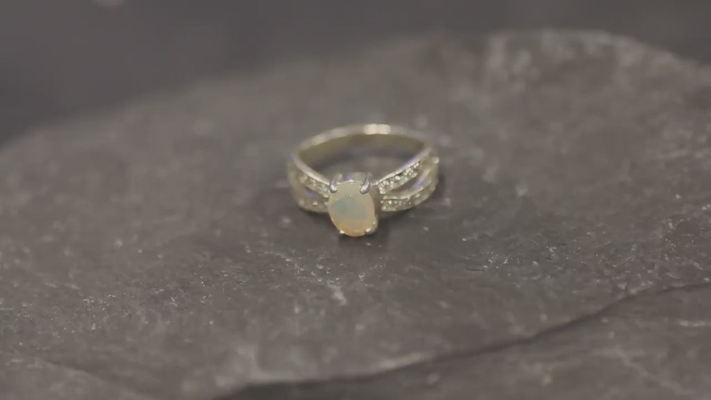 Opal Ring with split shank band and CZ pave setting showing flashes of fire colors, designed as elegant fine jewelry. Known for its emotional healing and creativity benefits, Opal is also the October birthstone and a thoughtful gift for birthdays or anniversaries. Perfect to wear at weddings, romantic dinners, and special evening celebrations.