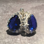 A serene landscape featuring rolling hills under a clear blue sky, with lush greenery and a few scattered clouds.