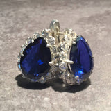 A serene landscape featuring rolling hills under a clear blue sky, with lush greenery and a few scattered clouds.