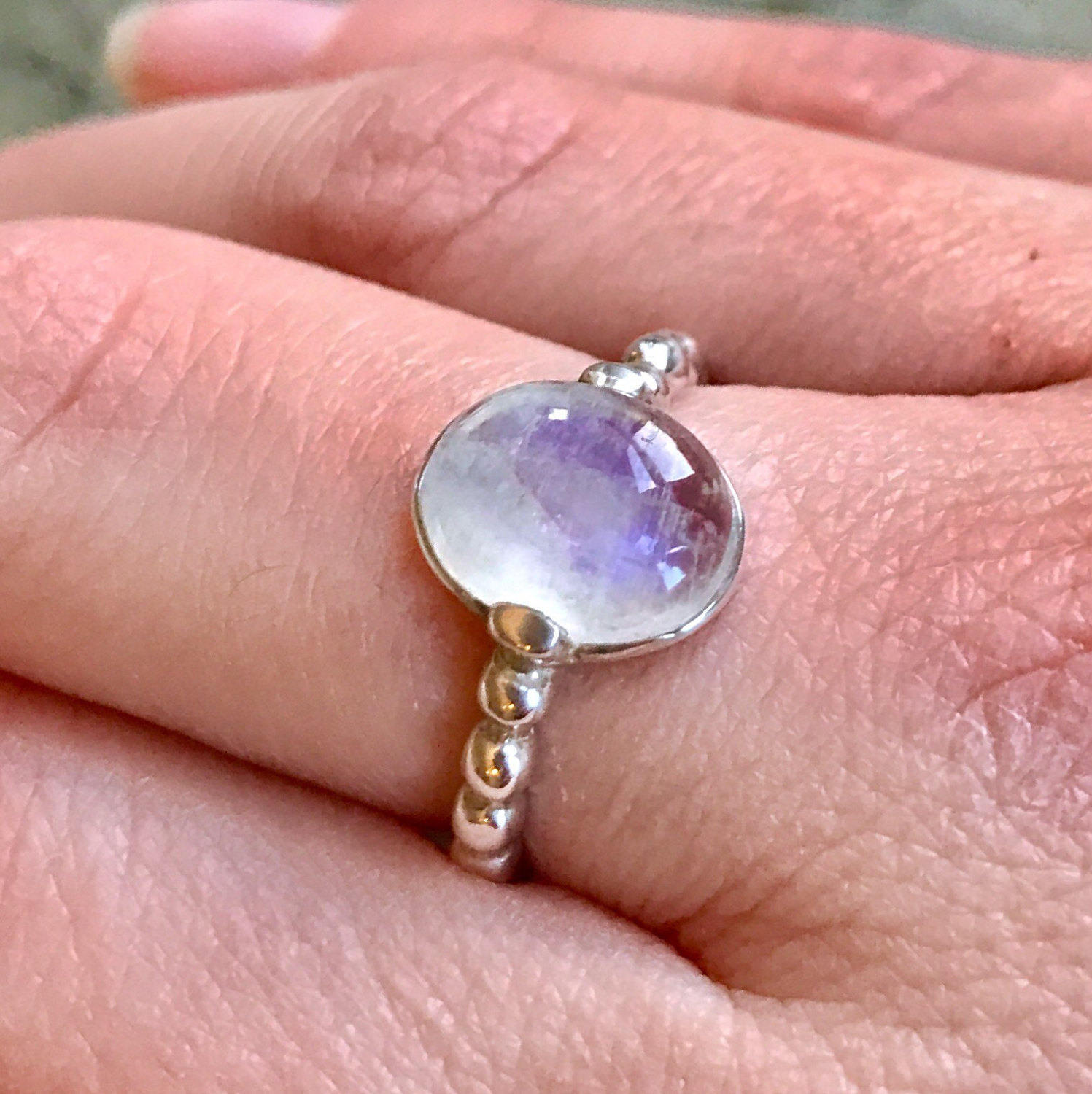 Rainbow Moonstone ring styled on the middle finger, paired with nude polish for a soft, grounded look—perfect for casual outfits and quiet weekends.