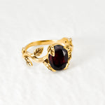 Red Garnet January birthstone ring set in 18k yellow gold vermeil over solid 925 sterling silver, in prong setting, and leaf-inspired band. Natural solitaire gemstone ring promotes energy, passion, and safety in travel. Often associated with love and commitment. Perfect for special occasions, and ideal birthday present
