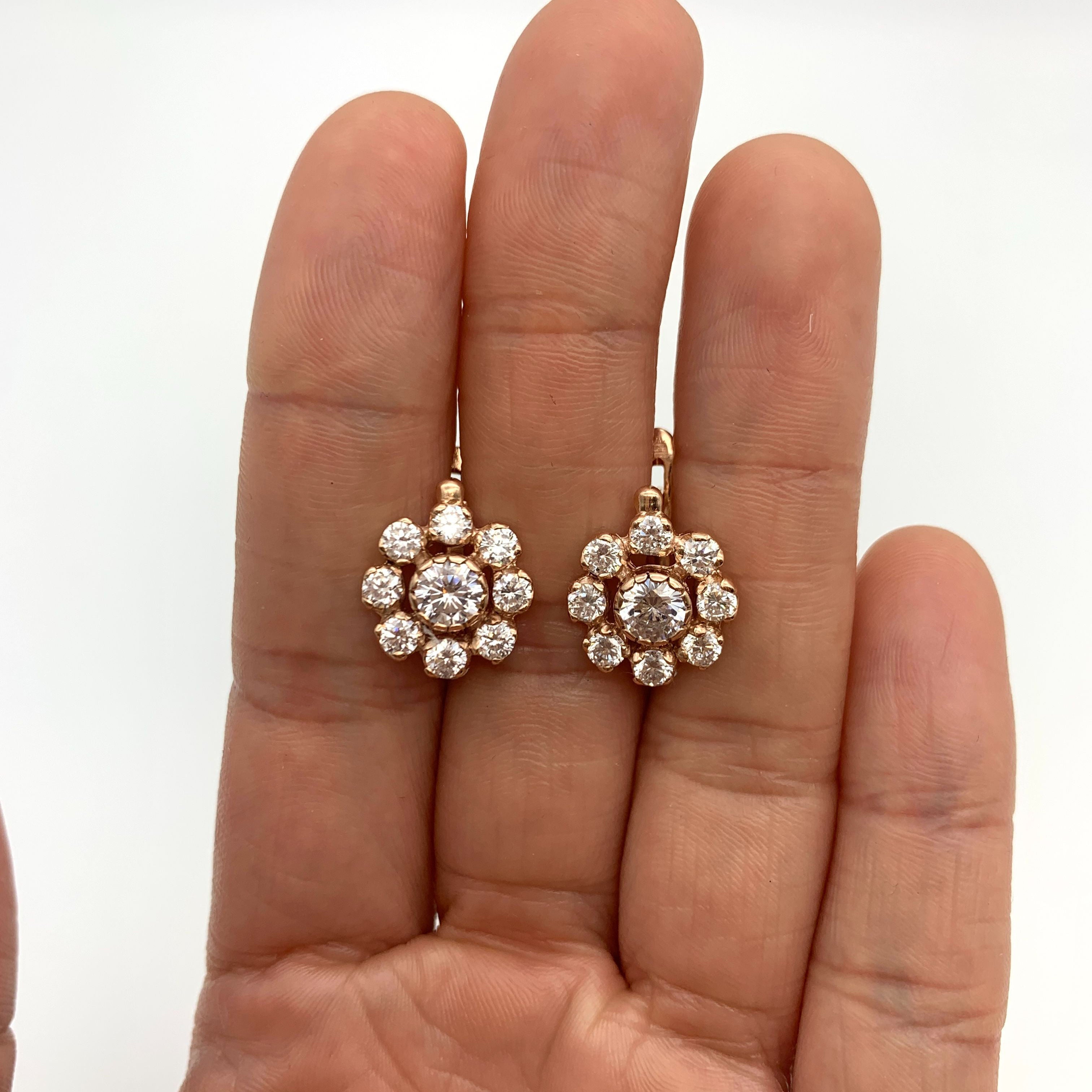 Rose Gold flower earrings set with CZ diamonds, displayed in an open palm – April birthstone jewelry, Symbol of eternal love, purity, and inner strength. For strength, clarity, abundance