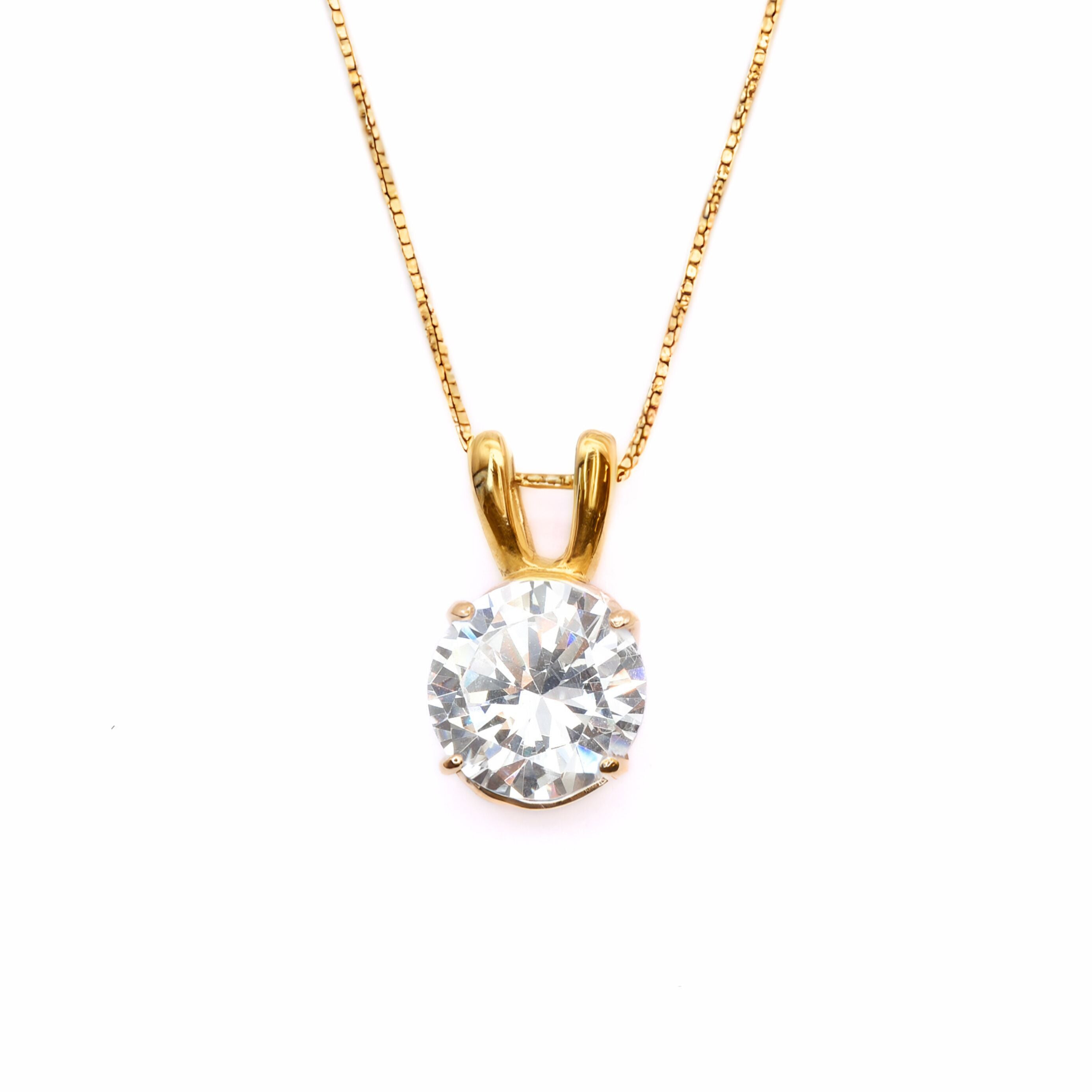 18k Yellow gold plated pendant with Diamond April birthstone in diamond and prong setting. Solitaire necklace ideal for special occasions and everyday wear. Round diamond necklace symbolizing eternal love, purity, and inner strength. Can be styled as elegant wedding necklace.