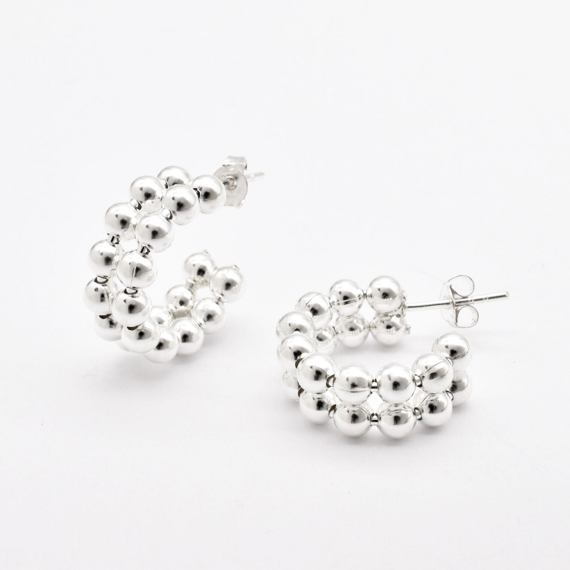 Front view of solid 925 sterling silver beaded hoop earrings on white background