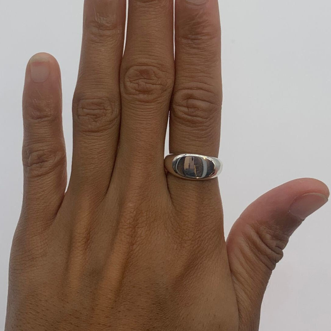 Hand model wearing a solid 925 sterling silver ring on the middle finger, highlighting its shine.