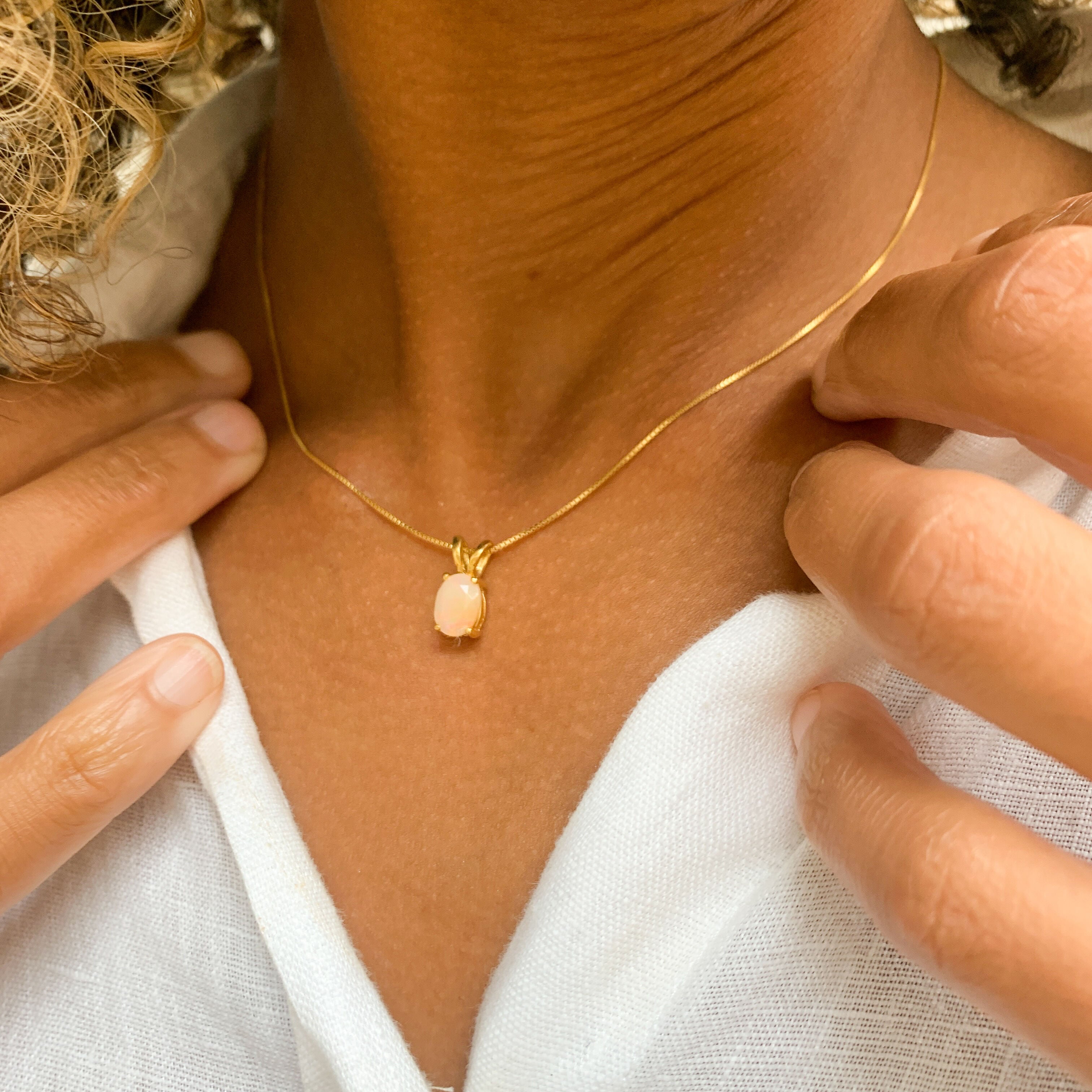 Woman wearing small Natural Opal necklace set in 18k gold vermeil over solid 925 sterling silver, in oval cut, and prong setting. October birthstone necklace perfectly worn for minimalist styles