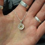 Sparkling green Peridot stone encircled by CZ accents, represents vitality and protection, perfect gift for August babies or gemstone lovers.